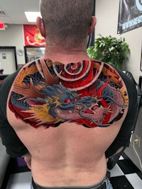 a man with a dragon tattoo on his back